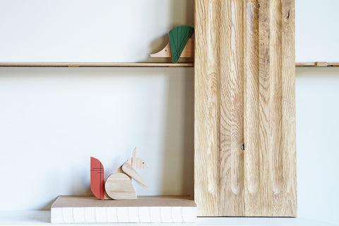 Wooden designer gifts on a shelf with a minimalist background