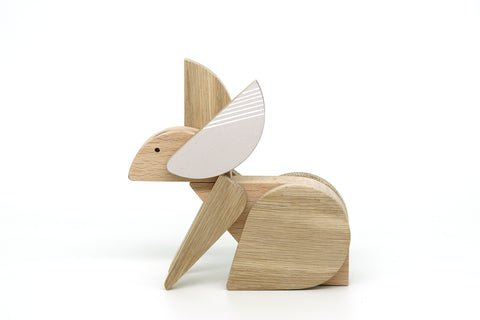 Wooden rabbit figurine with a white ear on a white background