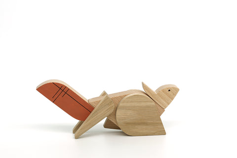 Wooden squirrel toy with red shell on a white background