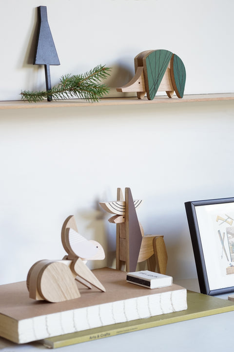 Wooden animal figurines on a shelf with a minimalistic background