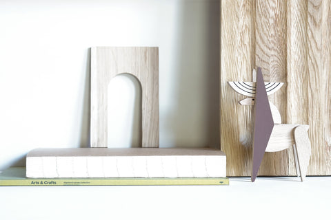 Wooden minimalst deer figurine with abstract designs on a wooden surface